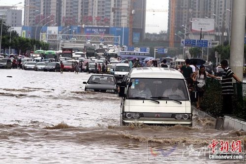 6月18日，車輛在武漢積水的道路上艱難行駛。當日，武漢降大到暴雨，全城多處交通要道積水嚴重，交通幾近癱瘓。中新社發 張暢 攝