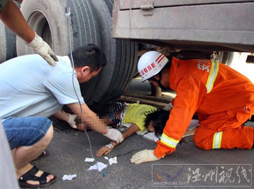 救援人員為壓在車輪下的女孩進(jìn)行輸液