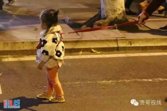 女子繩牽女兒逛街